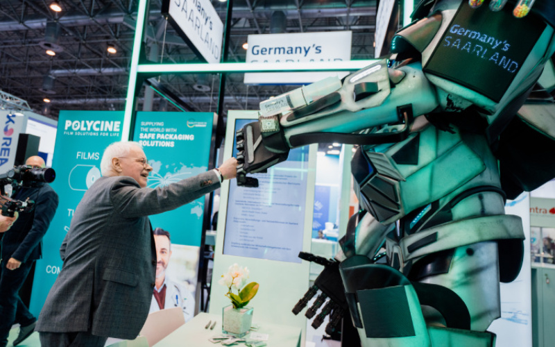 Stimmungsbild zur Messe. Walking Act Roboter und Minister Barke zu sehen.
